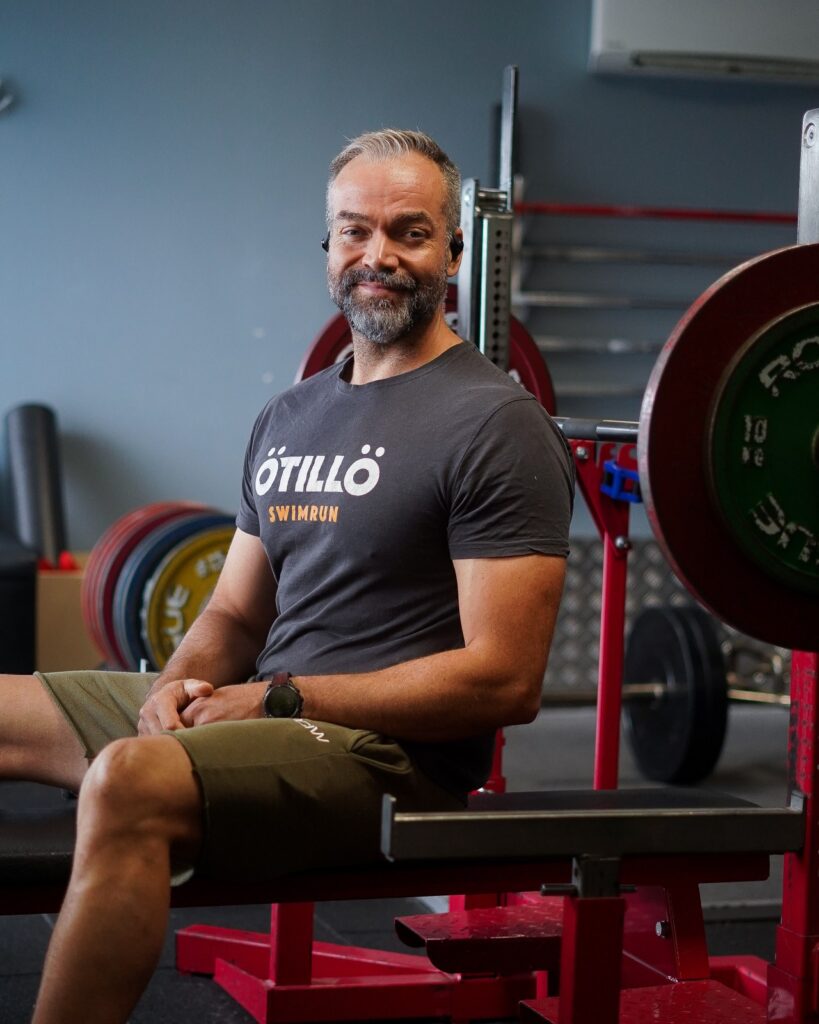 Coach Loyd smiler på benken i gymmen