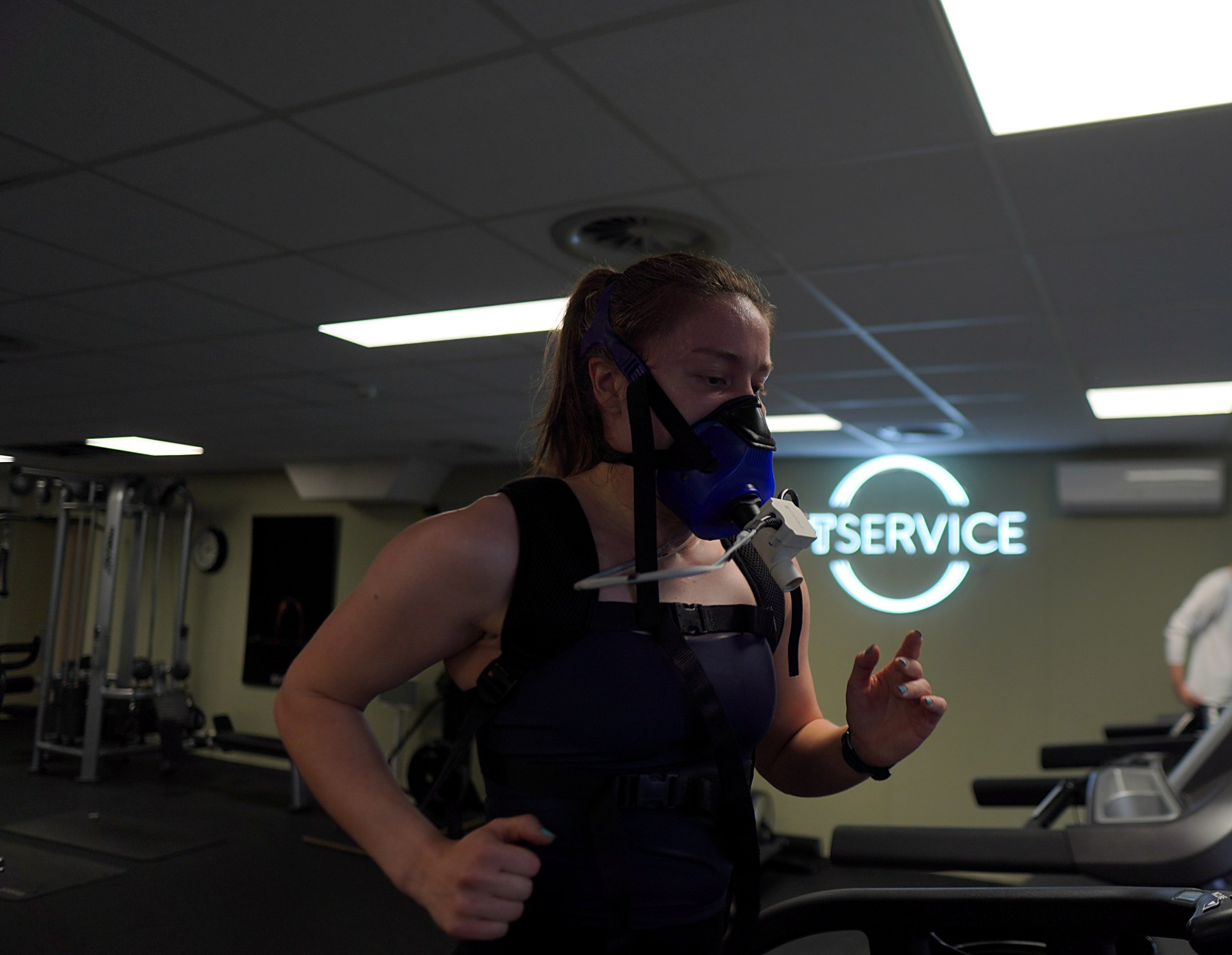 Kunde i full fart på tredemølla med VO2-maske